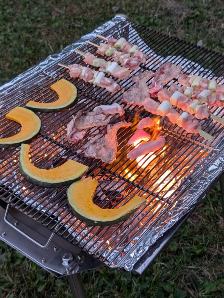 バーベキューで肉や野菜が焼かれている写真